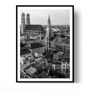Peut inclure: Une impression photographique en noir et blanc présentant une vue aérienne du paysage urbain de Munich, en Allemagne. La scène met en évidence les dômes en oignon emblématiques de la Frauenkirche et l'architecture gothique de l'hôtel de ville.