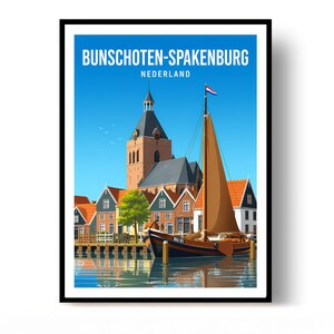 Op de afbeelding: Een ingelijste reisposter met de tekst BUNSCHOTEN-SPAKENBURG NEDERLAND. De illustratie toont een traditionele Nederlandse haven met een boot met bruine zeilen, een hoge kerktoren en bakstenen huizen met oranje daken onder een blauwe lucht.