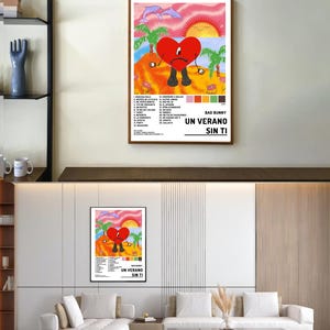 以下が含まれることがあります： ヤシの木のあるビーチで、靴とサングラスをかけた赤いハートが描かれたカラフルなポスター。ポスターの下には「Bad Bunny Un Verano Sin Ti」というテキストがあります。