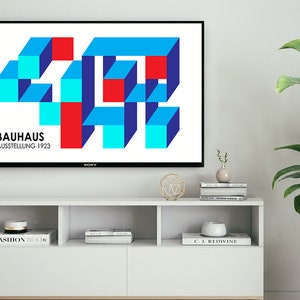 May include: A television screen displaying a geometric design in red, blue, and turquoise colors. The text "BAUHAUS AUSSTELLUNG 1923" is displayed below the design.