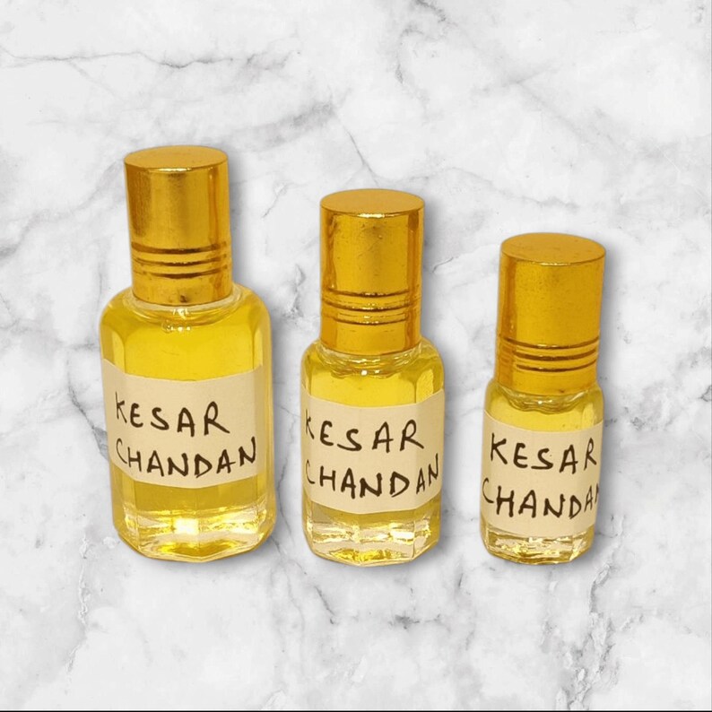 Handmade saffron sandalwood attar bottle with golden cap and natural background
