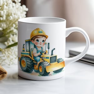 Pu&ograve; includere: Tazza in ceramica bianca con un'illustrazione di un bambino che indossa un casco giallo e guida un veicolo da costruzione giallo. Il veicolo ha la scritta "GRADER" stampata sul lato.