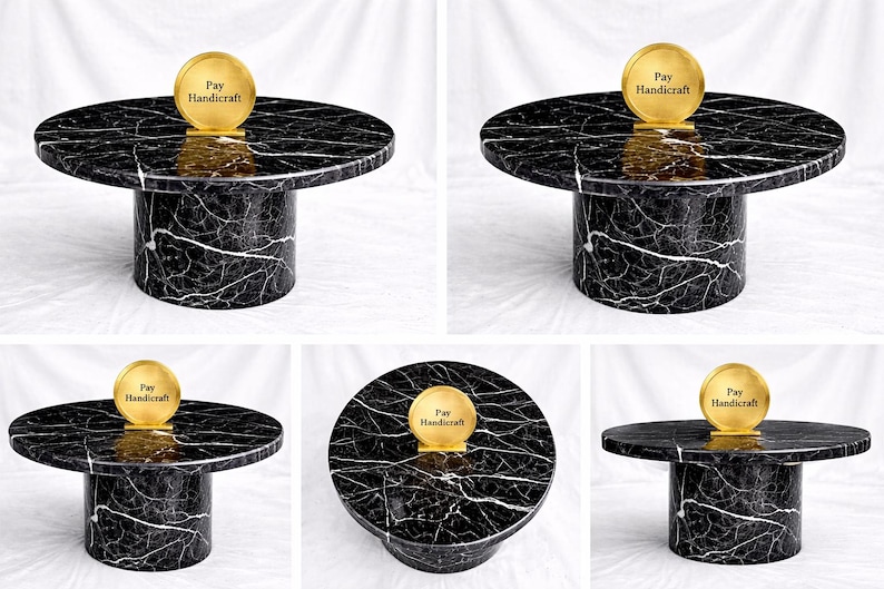 May include: A black and white marble-patterned coffee table with a cylindrical base. The round tabletop supports a gold-colored disc with the text "Pay Handicraft". The table is a modern design.