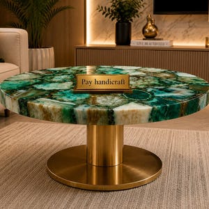 May include: A round coffee table featuring a polished green agate stone top with natural crystalline patterns and a gold-colored metal pedestal base. A small rectangular gold plaque with the text Pay handicraft is placed on the table surface.