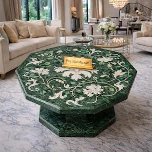 May include: An octagonal green coffee table with white floral inlay. The table has a two-tiered base and a gold sign that reads "Pay Handicraft". The table is in a living room setting.