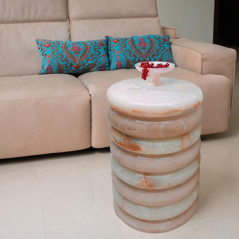 Designer table featuring a white onyx top and a unique donut-shaped body made of combined onyx and marble rings. Elegant and distinctive