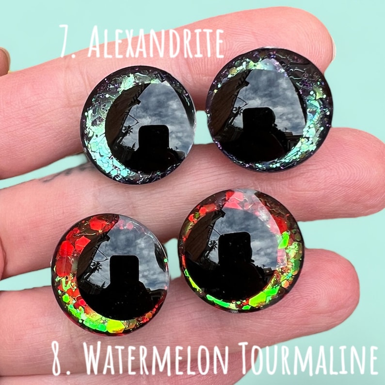 Puede incluir: Cuatro ojos redondos de vidrio iridiscente y colorido con pupilas negras. Los ojos est&aacute;n etiquetados como "7. Alexandrita" y "8. Turmalina sand&iacute;a".