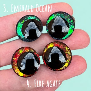 Puede incluir: Cuatro ojos redondos de resina negra con acentos de purpurina de diferentes colores. Los ojos est&aacute;n etiquetados como "3. Emerald Ocean" y "4. Fire Agate".