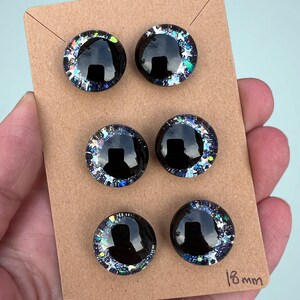 Three pairs of 18mm hand painted glittery safety eyes. They have off-set black pupils and galaxy glitter and silver stars.