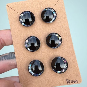 Three pairs of 16mm hand painted glittery safety eyes. They have off-set black pupils and galaxy glitter and silver stars.