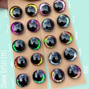 Puede incluir: Diez pares de ojos de pl&aacute;stico de 20 mm desplazados con detalles de purpurina. Los ojos est&aacute;n dispuestos en dos filas de cinco. Los ojos son negros con detalles de purpurina de diferentes colores. Los n&uacute;meros del 1 al 10 est&aacute;n escritos en el lado derecho de la imagen.