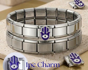 May include: A stainless steel modular link bracelet featuring a central hamsa hand charm with purple and white enamel details. The bracelet links are engraved with the text STAINLESS STEEL. Two additional hamsa hand charms are shown separately.