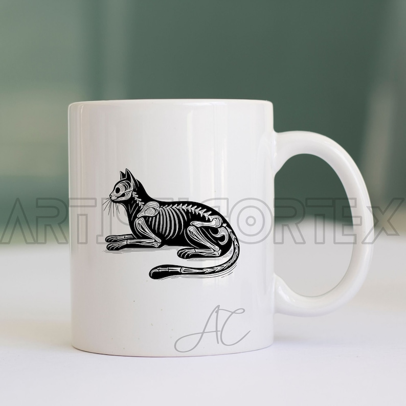 Puede incluir: Taza de cer&aacute;mica blanca con una ilustraci&oacute;n en blanco y negro de un esqueleto de gato. La taza tiene una inscripci&oacute;n en negro que dice "AC".