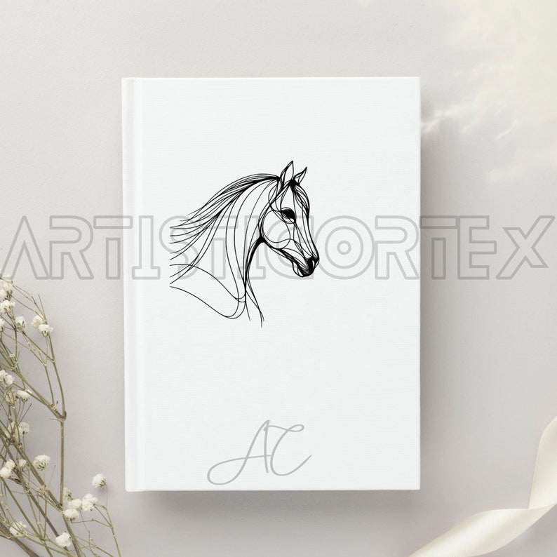 Op de afbeelding: Een wit notitieboek met een zwarte lijntekening van een paardenkop en de initialen "AC" in grijs.