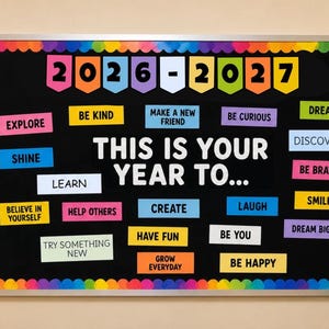 Op de afbeelding: Een rechthoekig prikbord met een zwarte achtergrond en een kleurrijke geschulpte rand. Het bevat de tekst 2026-2027 en THIS IS YOUR YEAR TO... omringd door diverse kleurrijke rechthoekige uitsneden met zinnen zoals BE KIND, LEARN en DREAM BIG.