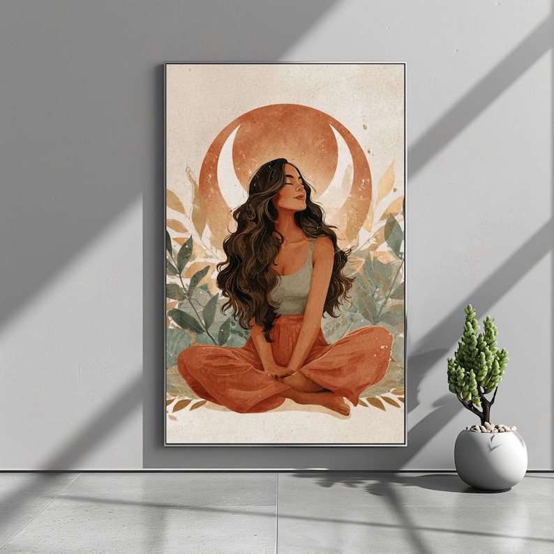 May include: A framed art print depicts a woman in a meditative pose. She is seated with her legs crossed, wearing a light green top and orange pants. The background features a crescent moon and foliage in warm tones.