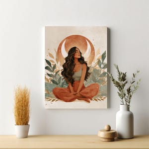 May include: A canvas print featuring a serene illustration of a person meditating. The artwork depicts a person with long, dark hair, wearing a sage green top and rust-colored pants, seated in a lotus position. A crescent moon and foliage frame the figure.