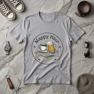 以下が含まれることがあります： 「Mappy Hour」と書かれた円形グラフィックが特徴のヘザーグレーのTシャツ。グラフィックにはコーヒーカップ、ビールジョッキ、地図のデザインが描かれています。その他、時計、サングラス、グレーのスニーカーなどがあります。