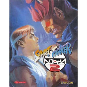 Puede incluir: Portada del videojuego Street Fighter Alpha 2 con dos personajes enfrentados. El título está en una fuente estilizada con un logotipo "Alpha 2". El fondo es un degradado de azules y morados.