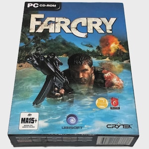 May include: A Far Cry PC CD-ROM game box. The cover art shows a man holding a gun in water, with a tropical island and explosions in the background. The game is rated MA15+ for medium level animated violence.