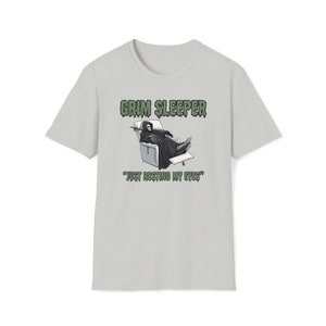 May include: A light gray t-shirt with a green graphic of a skeleton in a recliner with the text "GRIM SLEEPPER" and "JUST RESTING MY EYES".