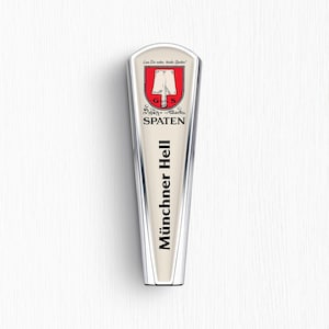 May include: A cream-coloured beer tap handle with a tapered shape and silver trim. It features the Spaten logo with a red shield and shovel icon, the text "Lass Dir raten, trinke Spaten!", "Schutz-Marke", "SPATEN", and "Münchner Hell" in black lettering.