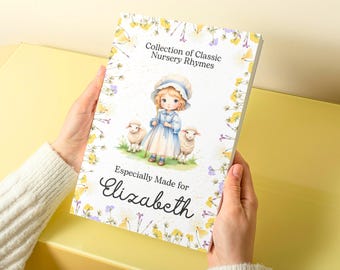 Puede incluir: Un libro blanco con un borde floral amarillo. La portada presenta a una niña con un vestido azul y un gorro blanco sosteniendo un cayado de pastor. Dos corderos blancos están a su lado. El título dice "Collection of Classic Nursery Rhymes". El texto "Especially Made for Elizabeth" está en la parte inferior de la portada.