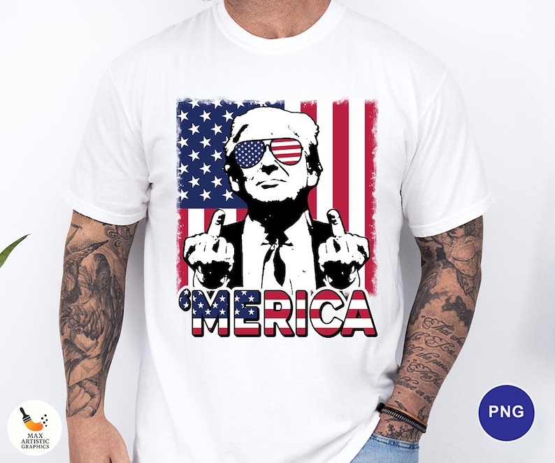 May include: White t-shirt featuring a graphic of a man wearing sunglasses with an American flag design. The man is giving the middle finger with both hands. The word "'MERICA" is printed in red, white, and blue.