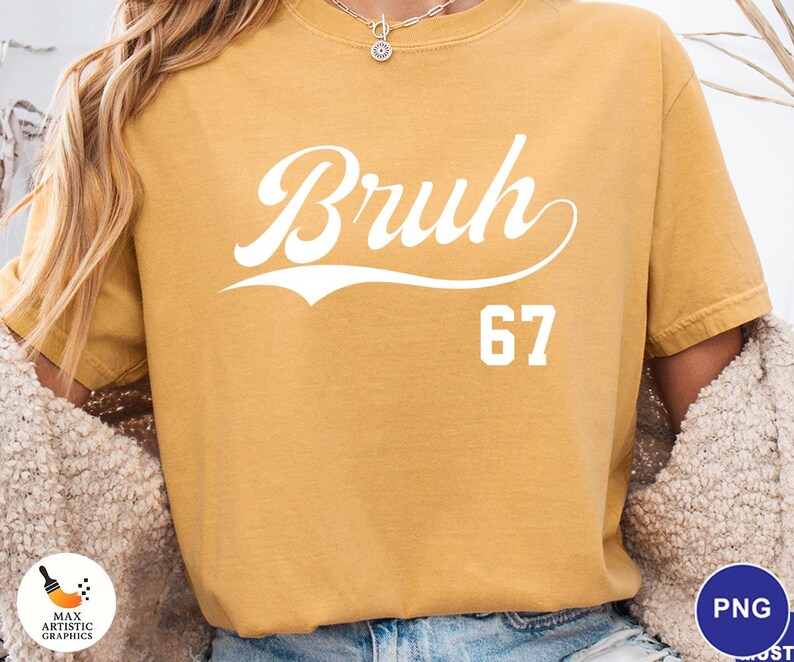 May include: Mustard yellow t-shirt with the word "Bruh" in white script, above the number "67". The shirt has a vintage, slightly faded look. The design is centered on the front of the shirt.