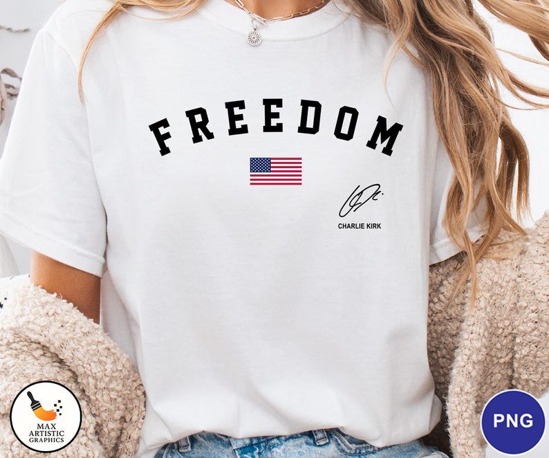 May include: White t-shirt with the word "FREEDOM" in black arched lettering above a small American flag graphic. Below the flag is a signature and the name "Charlie Kirk".