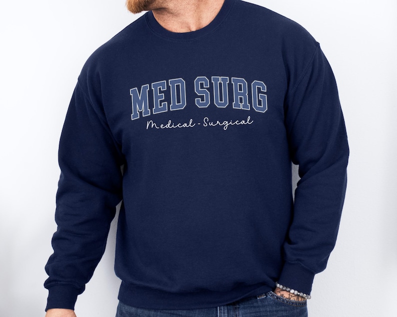 May include: Navy blue sweatshirt with the text "MED SURG" in a collegiate style font, with the words "Medical - Surgical" underneath. The sweatshirt is a solid navy blue color.