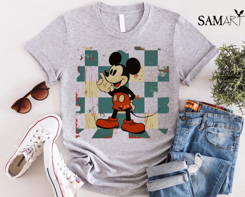 May include: A gray t-shirt with a vintage-style image of Mickey Mouse on a checkered background. The image is in shades of red, blue, green, and yellow.