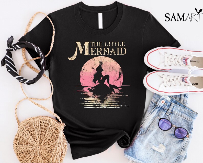 May include: Black t-shirt with a vintage-style graphic of a mermaid with the text "The Little Mermaid" in white.