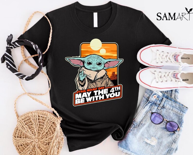 May include: Black t-shirt with a graphic of a green alien character with large ears. The text "Star Wars Day May the 4th Be With You" is printed below the character.