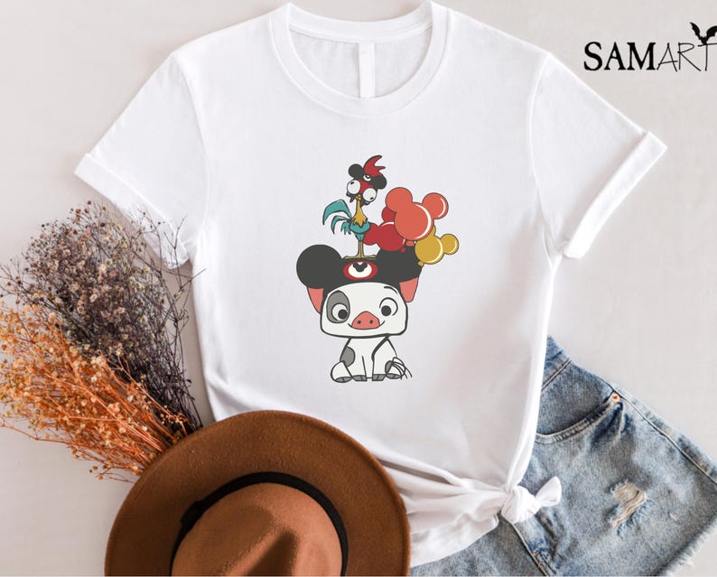 May include: White t-shirt featuring a cartoon illustration of a pig with a rooster on its head and red, yellow, and orange balloons. The shirt has the word "SAMART" printed on the upper right side.