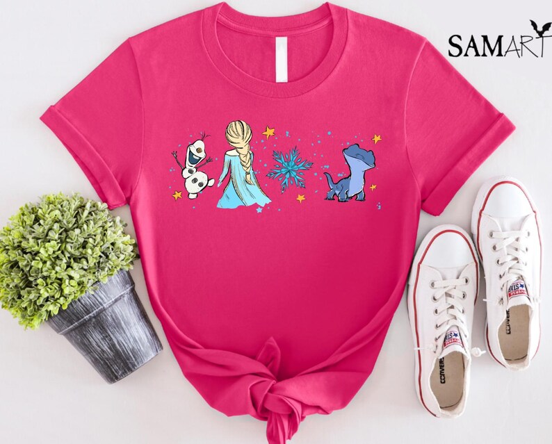 May include: A hot pink t-shirt featuring a cartoon design of characters from the movie Frozen, including Elsa, Olaf, and Bruni. The shirt is paired with white sneakers. The brand name "SAMART" is printed in the upper right corner.