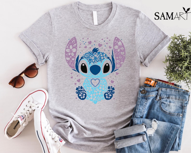 May include: A gray t-shirt with a blue and purple Stitch character design. Stitch is surrounded by hearts and flowers.