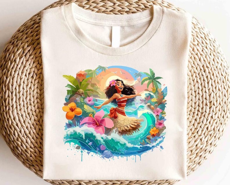 Pode incluir: T-shirt creme com uma ilustra&ccedil;&atilde;o colorida de uma mulher dan&ccedil;ando em uma onda, cercada por flores tropicais e palmeiras. A mulher usa um top listrado vermelho e branco e uma saia bege. O fundo inclui um p&ocirc;r do sol e o oceano azul.