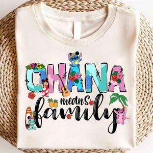 May include: A white t-shirt with a colorful graphic design featuring the text "Ohana means family" with Stitch and other characters from the Disney movie Lilo & Stitch.