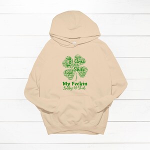 May include: A beige hoodie with a green four-leaf clover graphic that says "My Feckin Lucky Shirt".