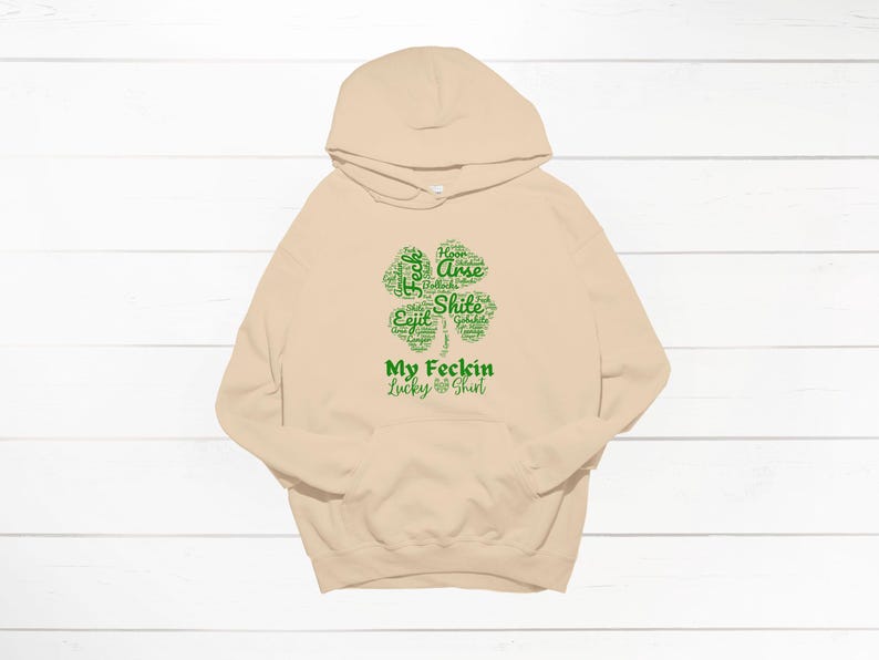 May include: A beige hoodie with a green four-leaf clover graphic that says "My Feckin Lucky Shirt".