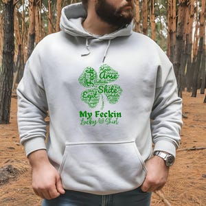 This Irish Swear Words Hoodie features a bold green shamrock filled with cheeky Irish expletives like Feck, Eejit, Gobshite, & Bollocks. Made from soft, cozy fabric, this unisex hoodie is perfect for St. Patrick’s Day fun, pub nights, and good craic!