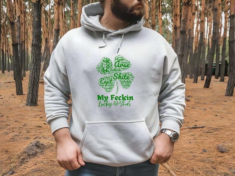 This Irish Swear Words Hoodie features a bold green shamrock filled with cheeky Irish expletives like Feck, Eejit, Gobshite, & Bollocks. Made from soft, cozy fabric, this unisex hoodie is perfect for St. Patrick’s Day fun, pub nights, and good craic!