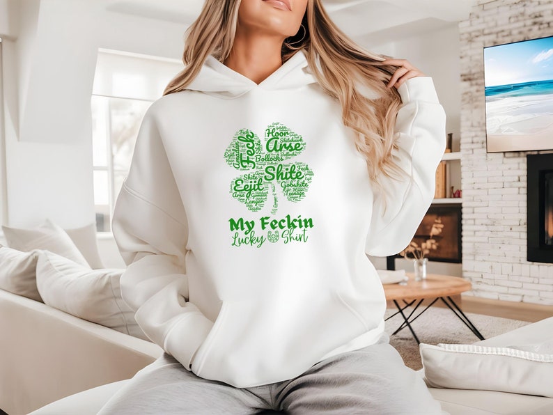 This Irish Swear Words Hoodie features a bold green shamrock filled with cheeky Irish expletives like Feck, Eejit, Gobshite, & Bollocks. Made from soft, cozy fabric, this unisex hoodie is perfect for St. Patrick’s Day fun, pub nights, and good craic!