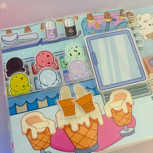 Puede incluir: Un colorido juego de tienda de helados con una variedad de sabores de helado, ingredientes y conos. El juego incluye un refrigerador, un mostrador y tres taburetes. El juego est&aacute; hecho de cart&oacute;n y es perfecto para juegos imaginativos.