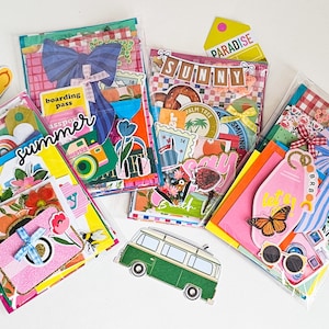 May include: Several clear plastic pouches filled with colorful summer-themed ephemera. Each pouch contains stickers, tags, and decorative paper with images of cameras, flowers, and travel motifs. The word "summer" is written on one pouch.