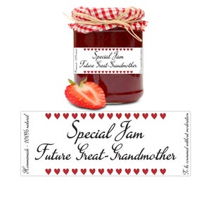 Pode incluir: Um rótulo branco com corações vermelhos ao redor da borda e o texto "Special Jam Future Great-Grandmother" em fonte cursiva preta. O rótulo está preso a um frasco de vidro cheio de geleia vermelha e coberto com uma tampa xadrez vermelha e branca.