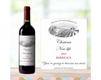 May include: A bottle of red wine with a label that says "Chateau Nouvelle Vie 2023 Bordeaux". The label also has a drawing of a vineyard. The bottle is sitting on a table with a white background. The label on the bottle says "You're going to become an aunt".