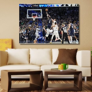 May include: A rectangular canvas wall art print featuring a professional basketball game in progress. The image captures players in dark blue and white uniforms competing near the hoop, with a large crowd visible in the background arena seating.
