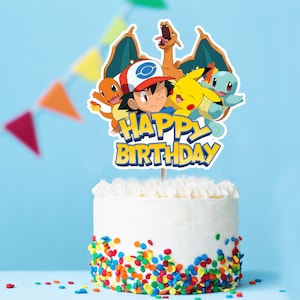 May include: A white cake with colorful sprinkles and a Pokemon themed cake topper that says "Happy Birthday". The topper features Pikachu, Charmander, Bulbasaur, and Ash Ketchum.